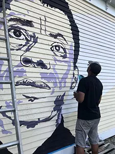 Artist Joe Diggs creating the mural