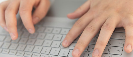 student typing on laptop