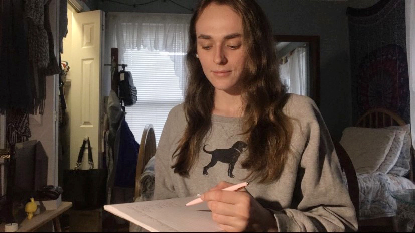 A student writing on a pad of paper